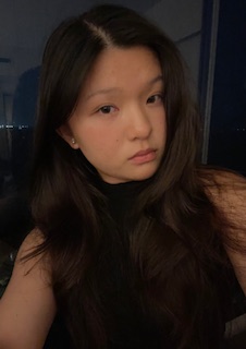 Image of Angeleen wearing a black top with the night sky in the background.